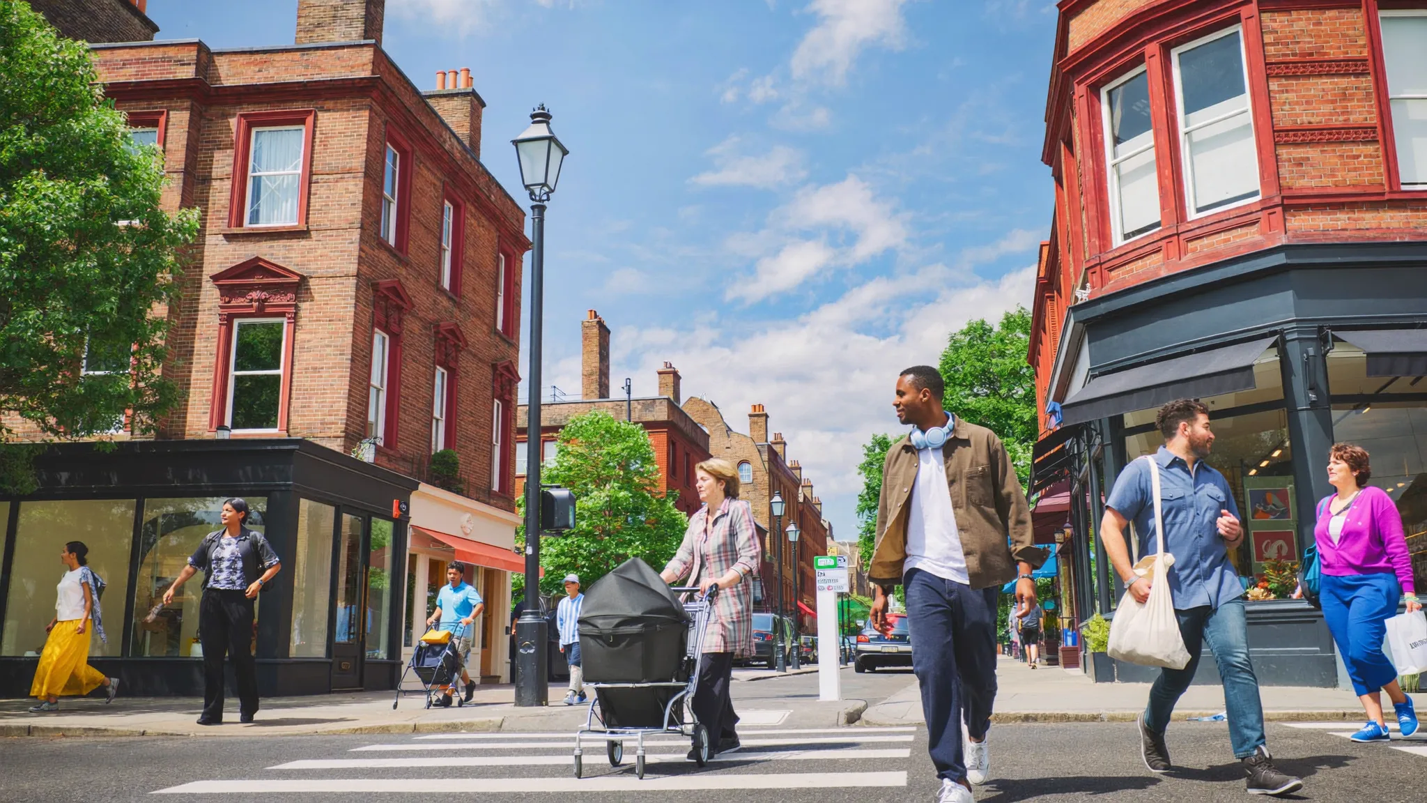 People from different walks of life crossing a sunlit British high street