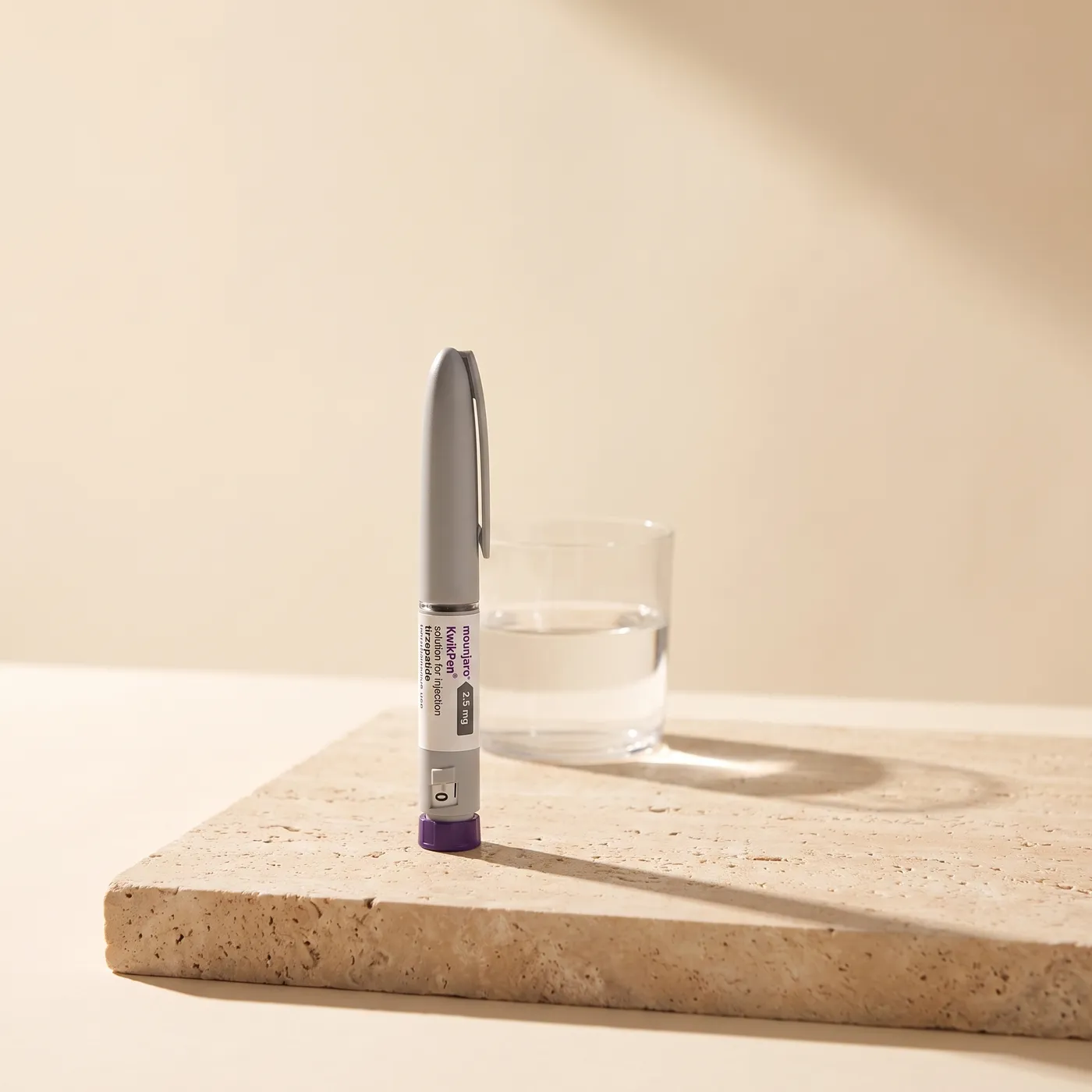 Mounjaro KwikPen standing on a travertine surface in soft morning light